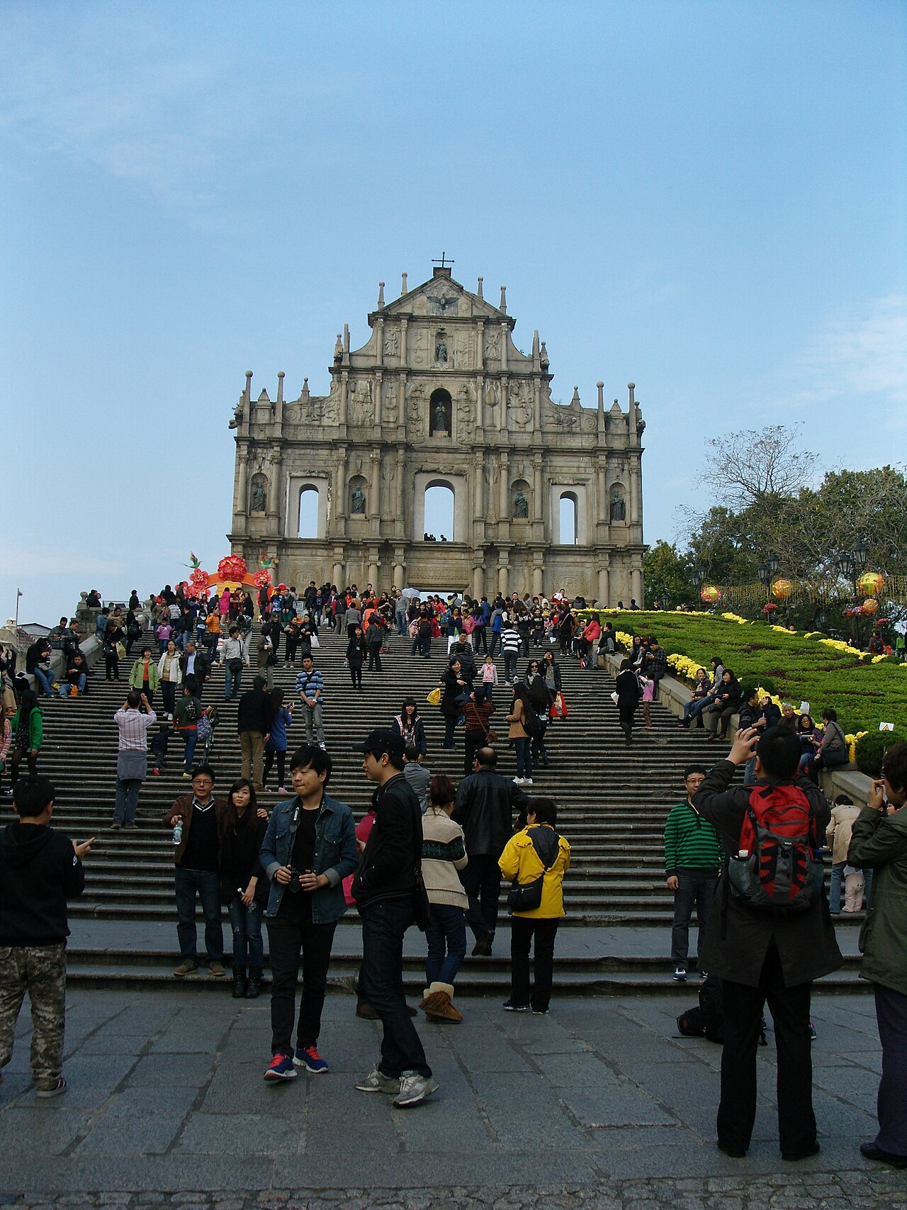 Die gemeißelte Steinfassade von St Paul's, die allein am oberen Ende einer langen Treppe steht, mit Besuchern, die sich über die Stufen verteilen.
