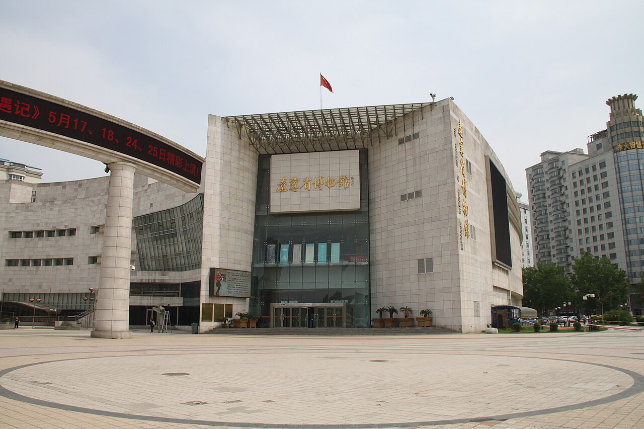 Die moderne Fassade aus grauem Stein des Provinzmuseums Liaoning über einem weitläufigen Eingangsplatz.