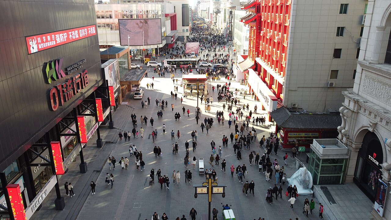 Menschenmengen zwischen Geschäften und Imbissständen auf der Zhongjie, Shenyangs alter Einkaufsstraße.