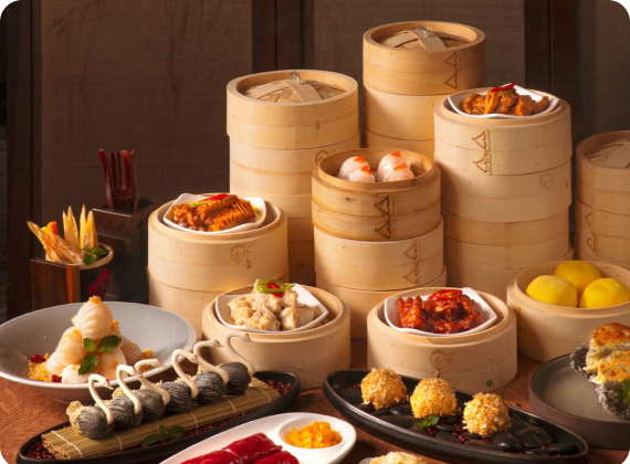 Stacked bamboo steamers of dim sum on a wooden table