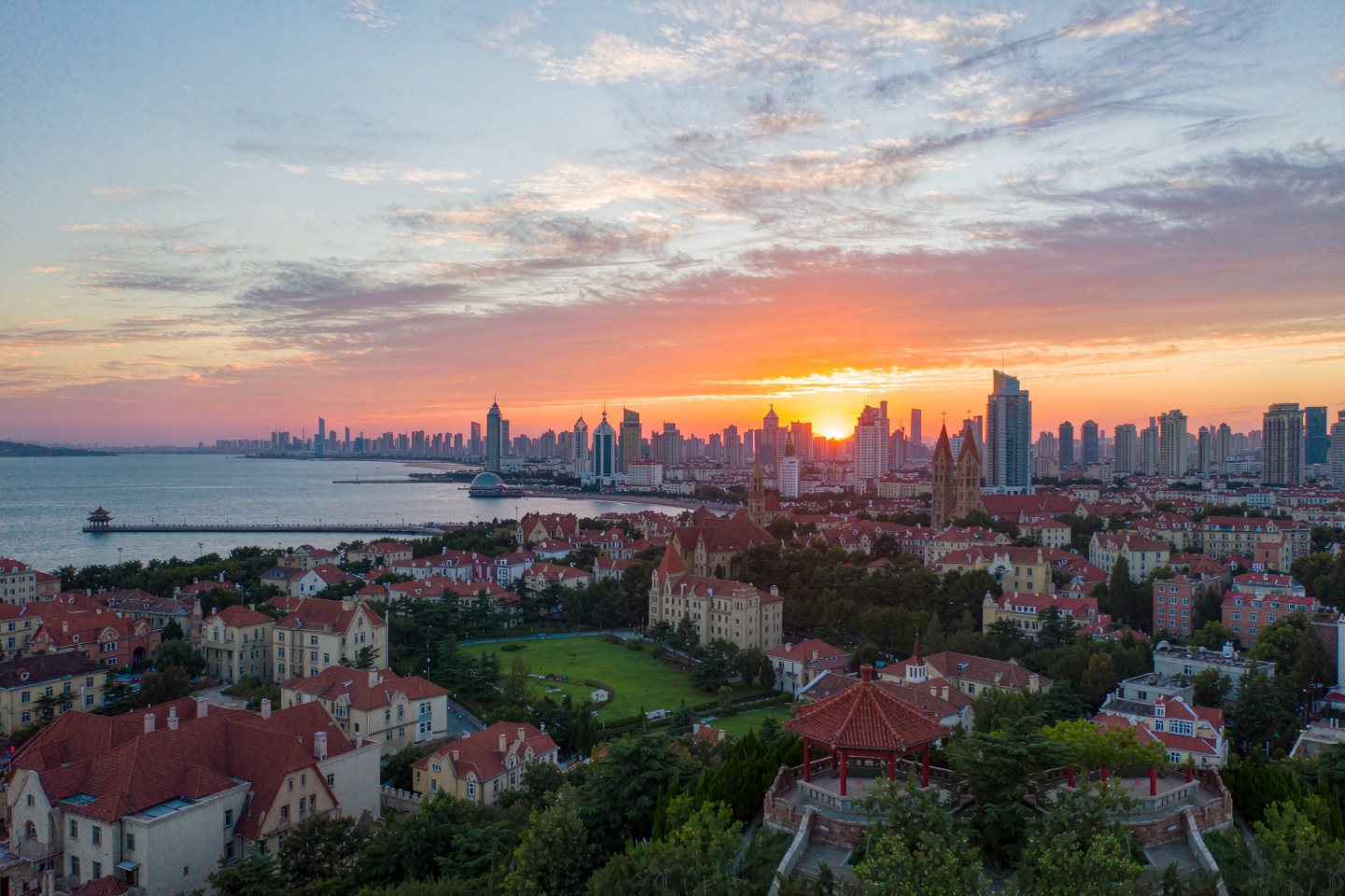 Atardecer sobre los tejados del casco antiguo y la bahía de Qingdao desde la Colina de la Señal