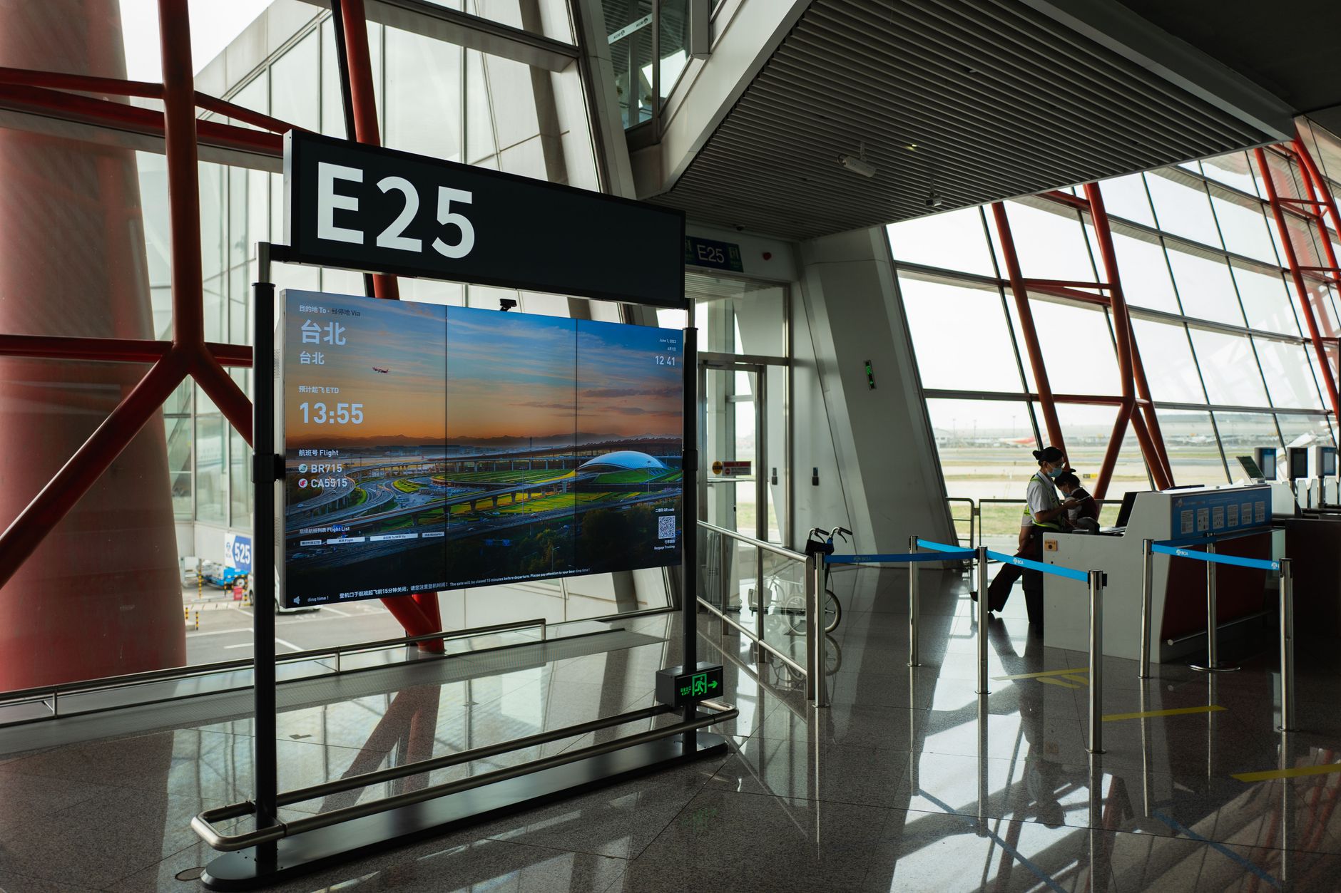현대적인 공항 터미널의 모습으로, Gate E25와 항공편 표시판을 보여줍니다.