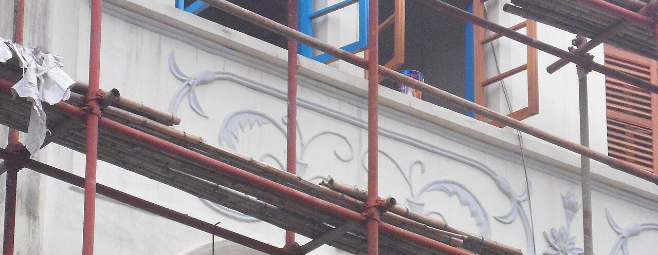 A century-old white qilou facade with arched balconies on Haikou's old street